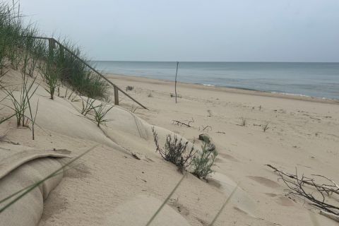 A sandy dune is seen in the foreground with Lake Michigan beyond
