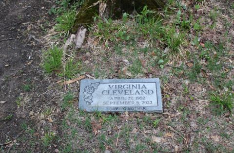 A gravestone is seen in the ground