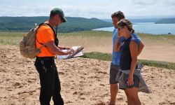 two volunteers with lakeshore in the background