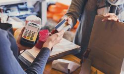 Customer paying for order of cheese in grocery shop.