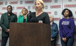 Nicole Beverly speaking at a podium, surrounded by other people