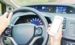 person holding phone in car