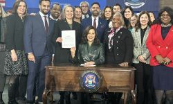 Gov. Gretchen Whitmer surrounded by lawmakers