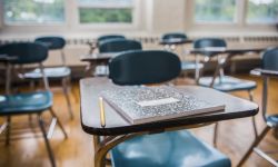  A notebook and pencil on a desk in a school classroom