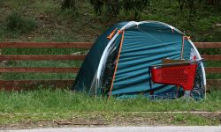 A bright red cart stands next to a blue tent used by a homeless person, A pending decision by the U.S. Supreme Court will decide whether governments can ban homeless camps in Michigan and other states. 