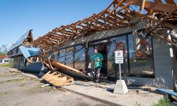 Severely damaged this Pizza Hut from a tornado in Portage, Michigan. A man is walking out of the store