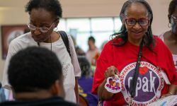 Gwendolyn Swain at a table at the Healthy Black Elders event in Detroit. She is wearing a red shirt