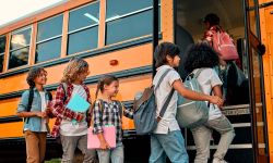 Children go into a yellow school bus