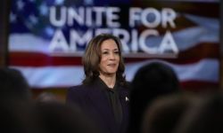 Kamala Harris on the stage, behind the stage says Unite for America