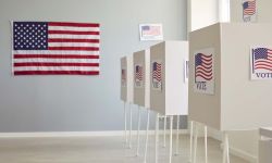 White empty voting booths at polling station with American flag