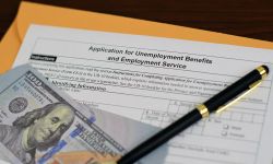 Cash, pen and an application for unemployment benefits 