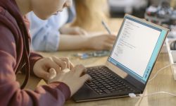 Young boy looks at a laptop in a classroom