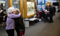 Two mature women hug each other at the Clinton Township Senior Center