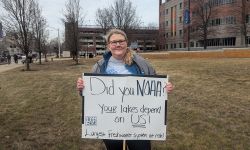 Nicole Rice holds a homemade sign supporting NOAA. 