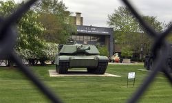 A huge tank can be seen through the gate.