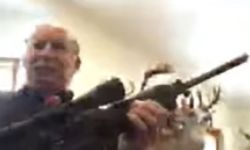 A blurry photo of Grand Traverse County Commissioner Ron Clous holding a rifle.