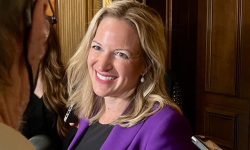 Secretary of State Jocelyn Benson wears a purple blazer.