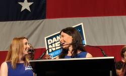 Attorney General Dana Nessel is on a stage next to her wife, Alanna Maguire.