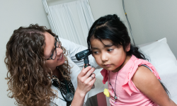 A doctor examines a young girl. 