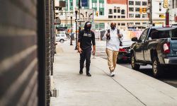 people wearing masks walking down the street