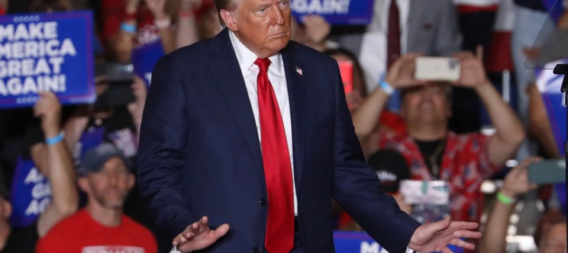 Donald Trump stands on stage at a rally