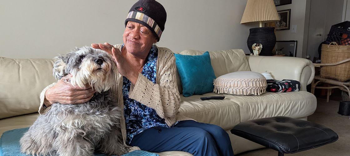 Tonya McCoy sits with a dog on a couch. 